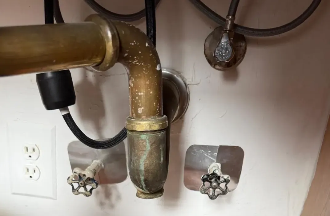 The same shut-off valves with steel escutcheon plates fitted over the openings